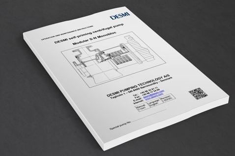 Manual for DESMI self-priming centrifugal pump, Modular S-N Monobloc, on a table.