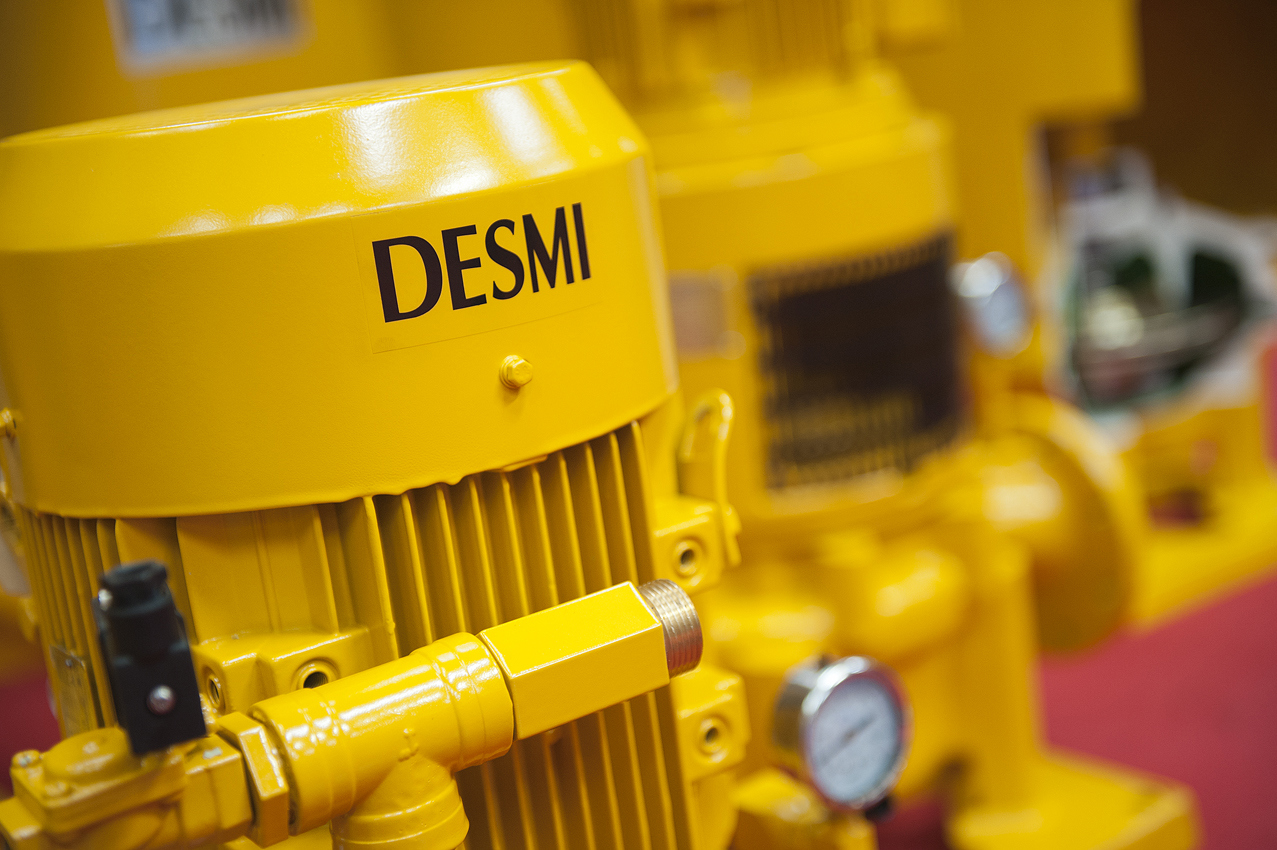 Yellow DESMI pump for fluid handling with gauge and fittings.