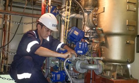 Technician working on a DESMI fluid handling system in an industrial setting.