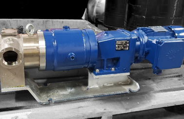 Blue industrial pump with metal fittings, mounted on a wooden pallet.