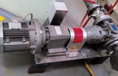 Industrial pump system with motor and pipes, used for fluid handling.