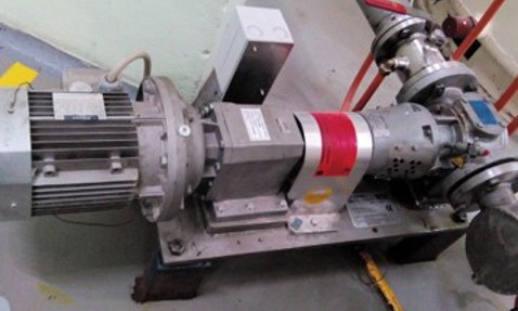 Industrial pump system with motor and pipes, used for fluid handling.