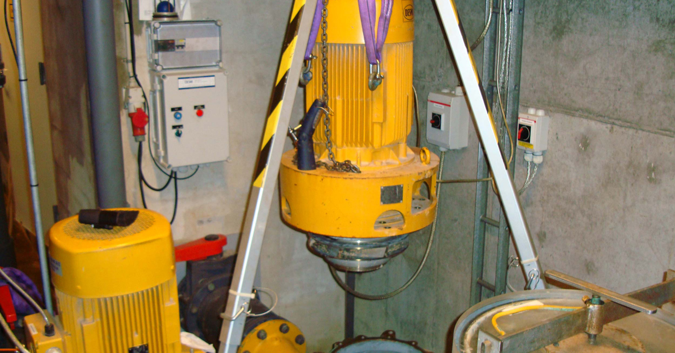 Yellow DESMI pump being installed in an industrial setting for fluid handling.