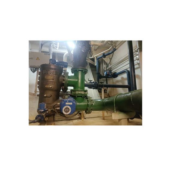 Industrial setup with DESMI filtration system and connected green piping for fluid handling.