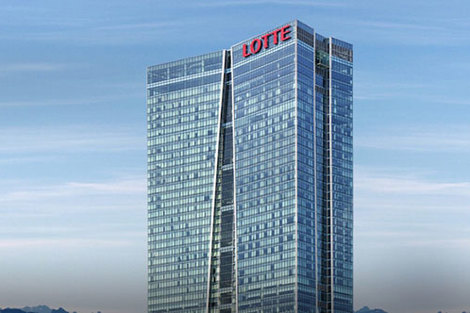 Tall glass skyscraper with "LOTTE" signage against a clear blue sky.