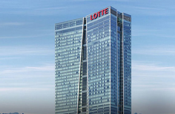 Tall glass skyscraper with "LOTTE" signage against a clear blue sky.