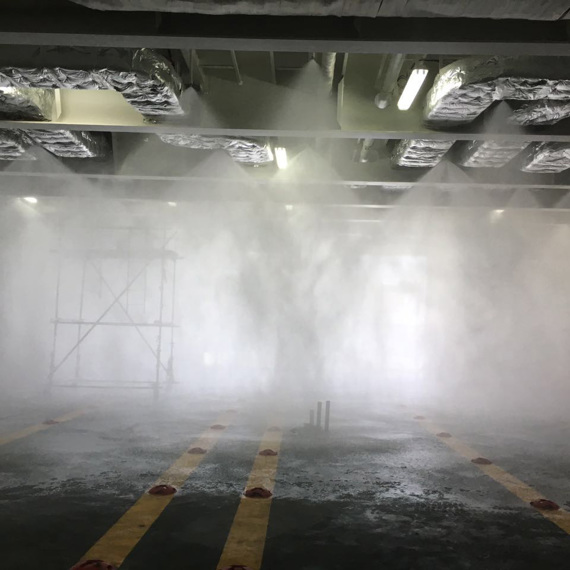 Test av sprinklersystem i en industriell miljö med dimma och ställning.