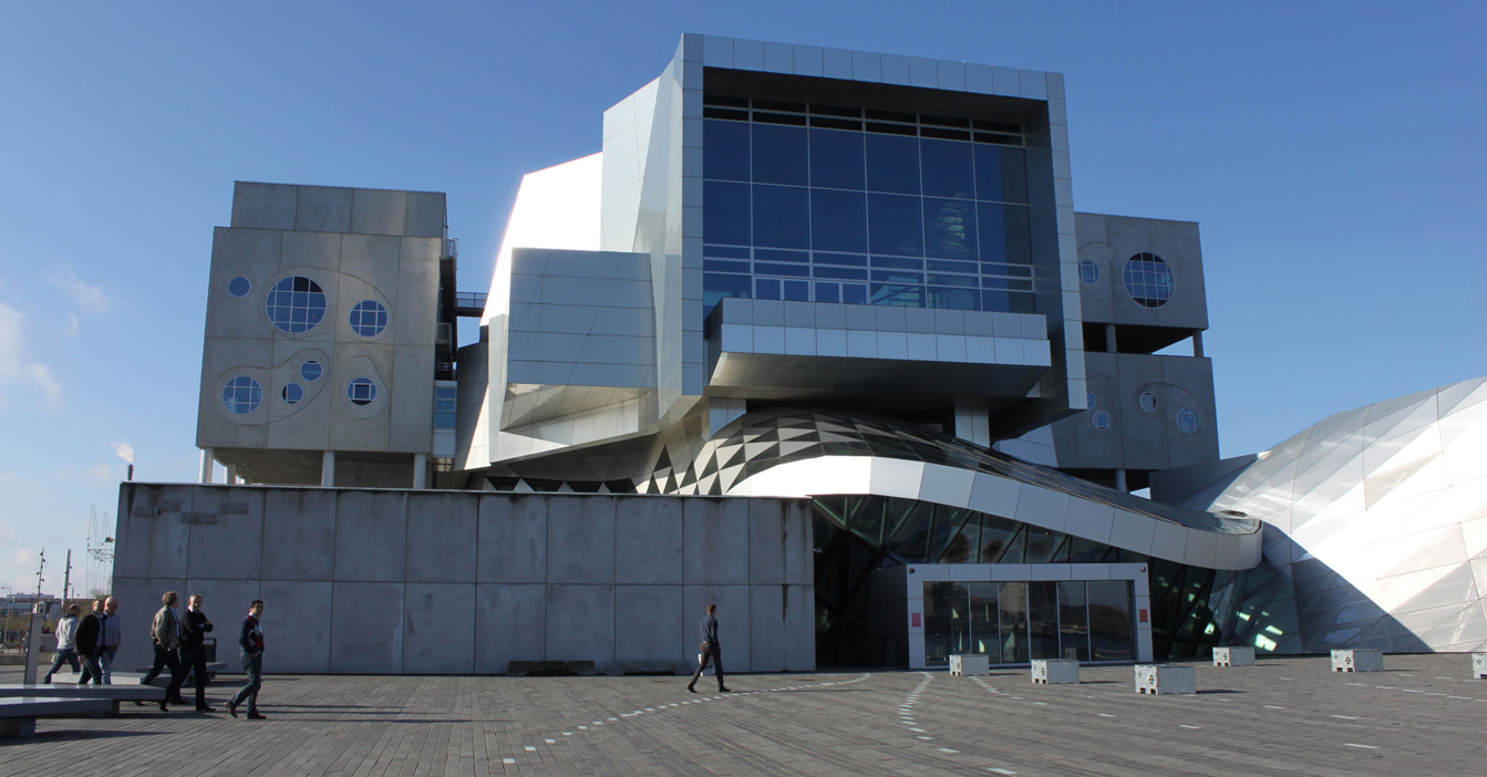 现代建筑，设有圆形窗户，前景中有人在行走。