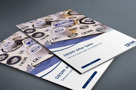 DESMI售后手册，带有公司标志，置于灰色表面。