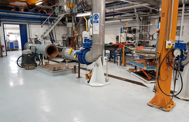 Industrial facility with large pipes and machinery for fluid handling and processing.