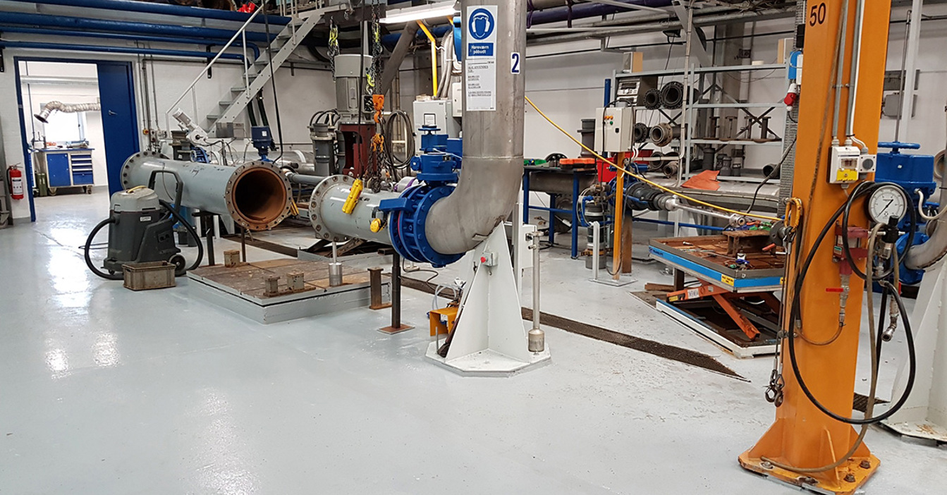 Industrial facility with large pipes and machinery for fluid handling and processing.