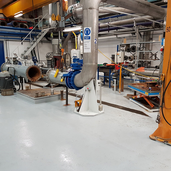 Industrial facility with large pipes and machinery for fluid handling and processing.