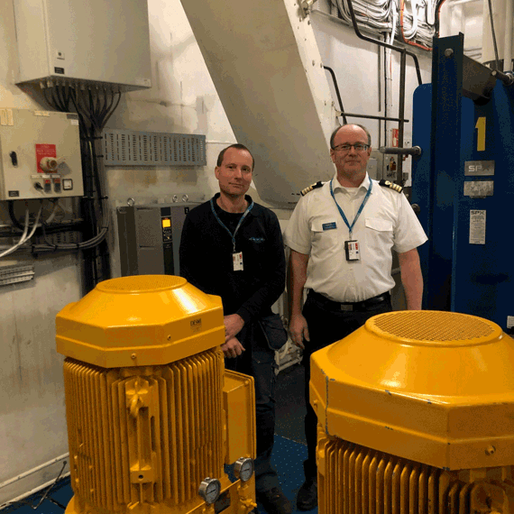 两名男子站在工业环境中的DESMI泵旁。