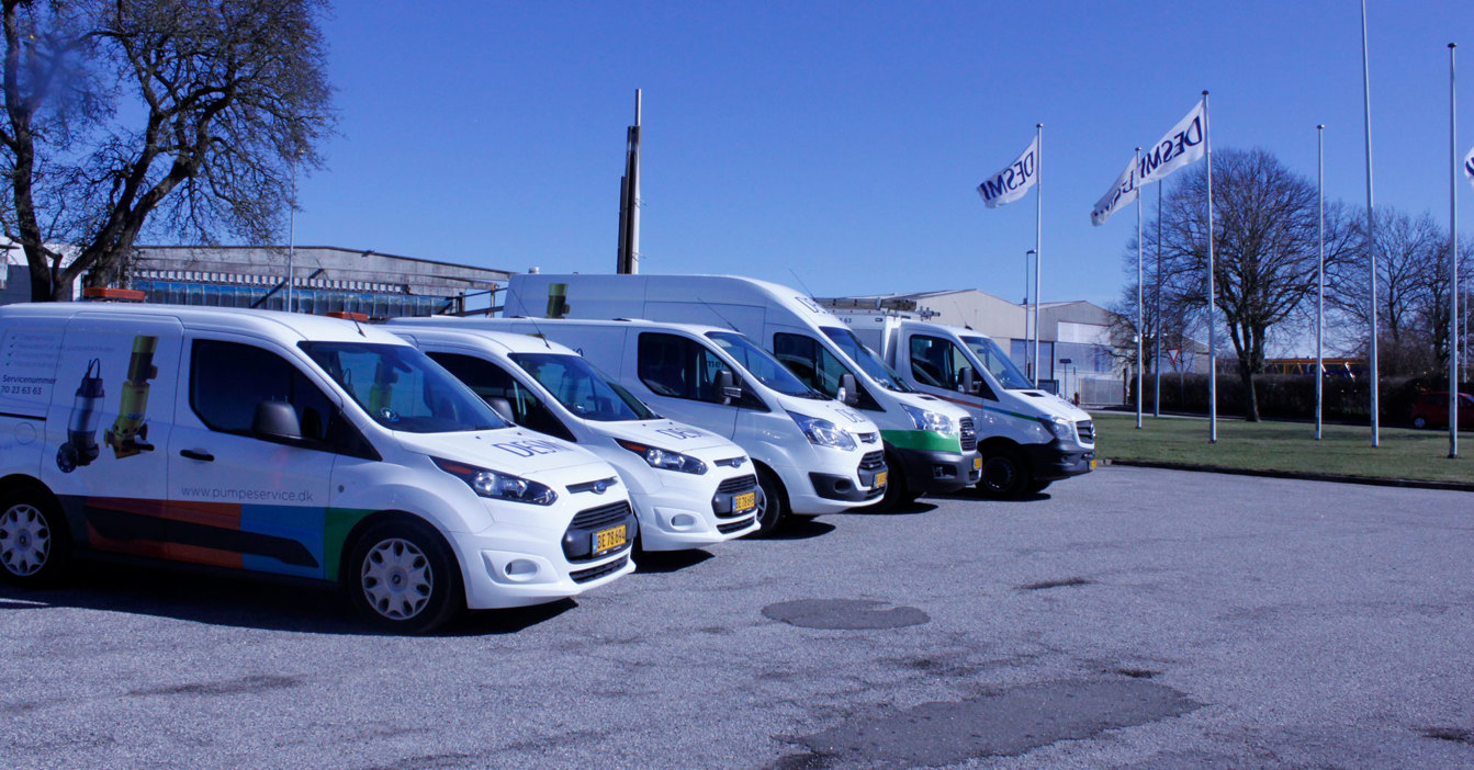 DESMI service vans parked with company flags in the background.