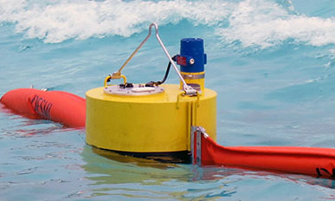 DESMI oil spill recovery skimmer floating in water with connected hoses.