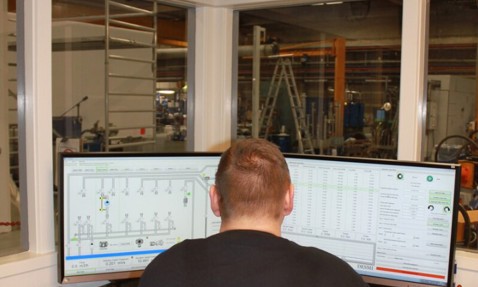 身穿DESMI衬衫的人在双屏上监控流体处理系统。