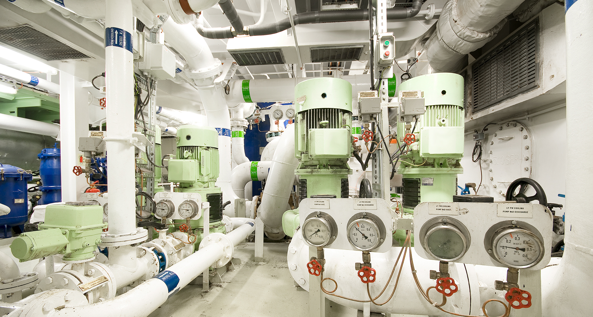 Sala industrial con múltiples bombas y medidores para sistemas de manejo de fluidos.