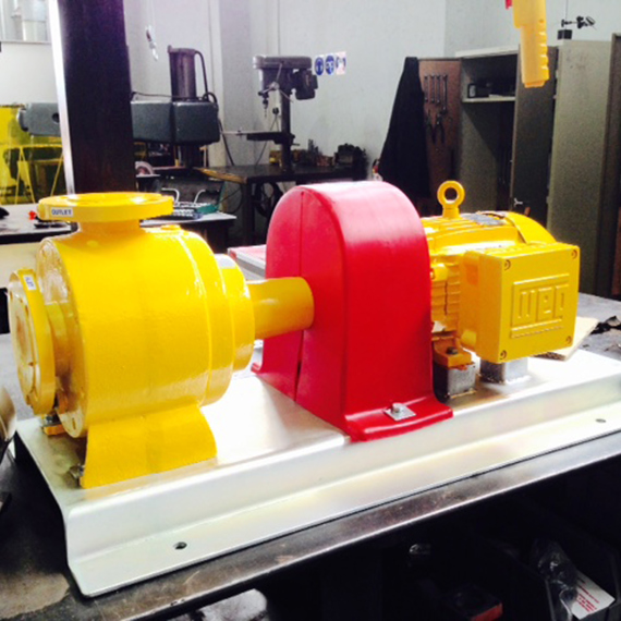 Yellow and red industrial pump on a workshop table for fluid handling.