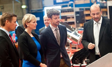 Group of people attentively viewing a presentation at an industrial event.