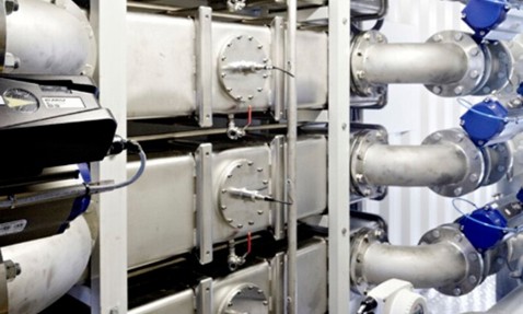 Industrial piping system with metal valves and gauges for fluid handling.