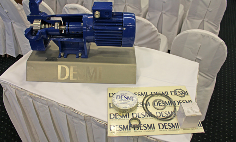 DESMI blue pump model on display table with promotional materials.