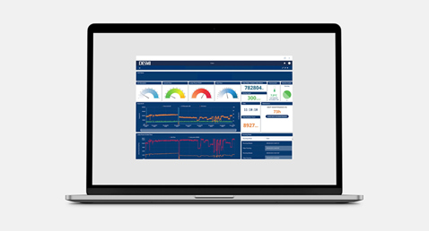 Dos hombres de pie junto a una bomba amarilla DESMI en un entorno industrial.