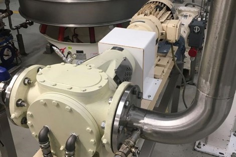 Industrial pump system with piping and machinery in a facility setting.