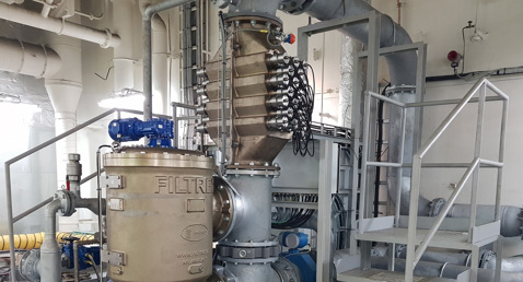 Industrial fluid handling system with pipes, valves, and a DESMI filtration unit.