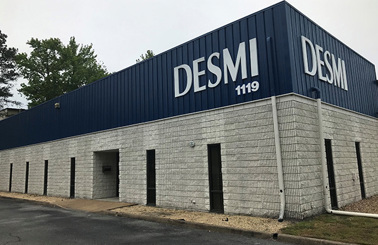 DESMI building exterior with blue and gray facade, labeled "DESMI 1119".