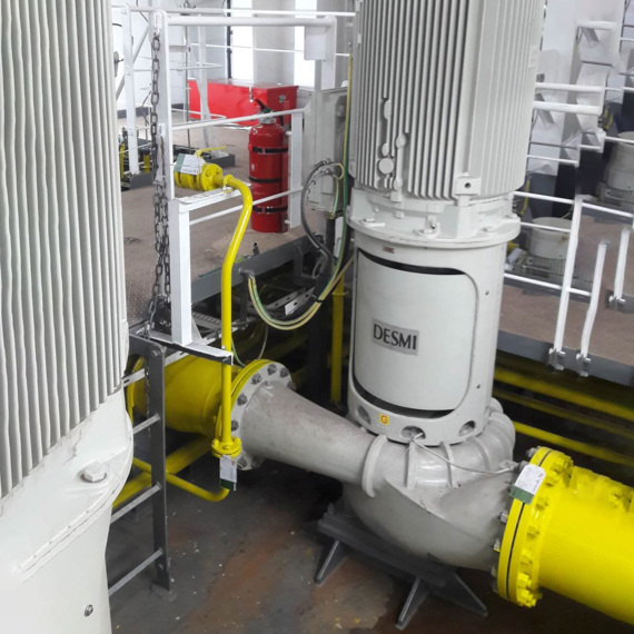 DESMI pump system with yellow piping and safety equipment in an industrial setting.
