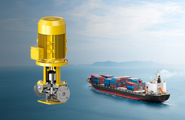 Yellow DESMI pump with a cargo ship in the background on the ocean.