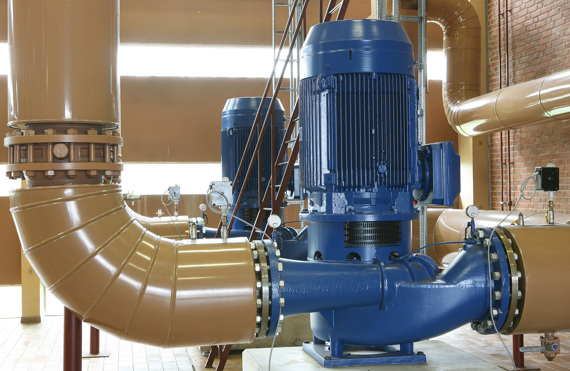 Pompe industrielle bleue connectée à de grands tuyaux marron dans une installation.