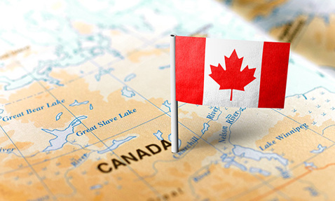 Canadian flag pin on a map highlighting Canada, near Great Bear Lake.