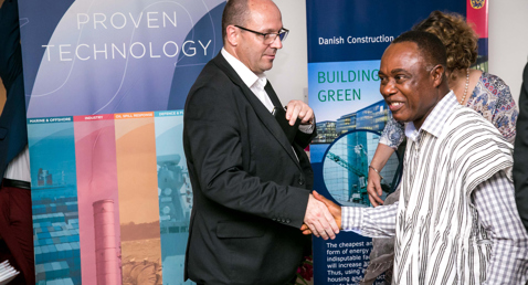 Two men shaking hands at a DESMI technology event in Ghana.