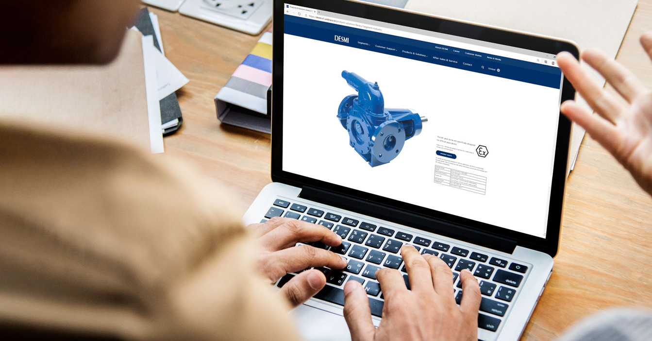 一个人在办公桌前的笔记本电脑屏幕上查看DESMI泵产品页面。