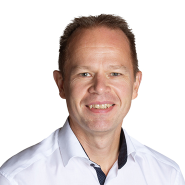 Smiling man in a white shirt against a plain white background.