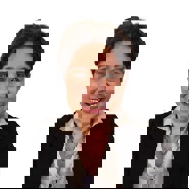 Smiling person wearing a black blazer and white shirt with a gold necklace.