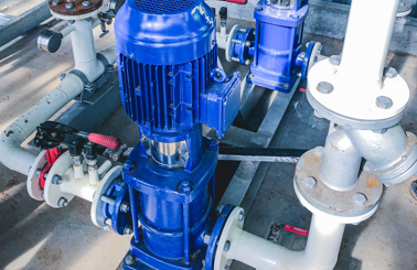 设施环境中，蓝色工业泵连接到白色管道。