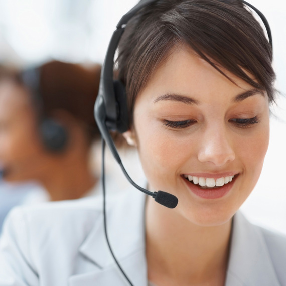 Smiling customer service representative wearing a headset, assisting clients.