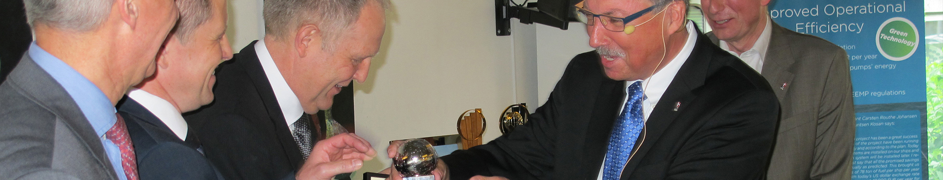 一群穿西装的男子在室内活动中检查一个闪亮的物体。