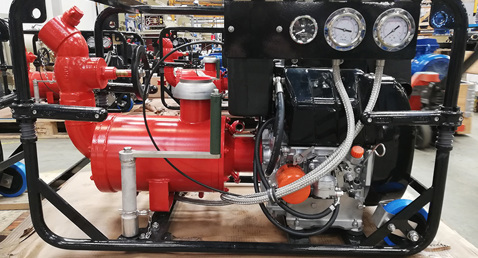 Red DESMI pump with gauges, hoses, and engine, used for fluid handling.