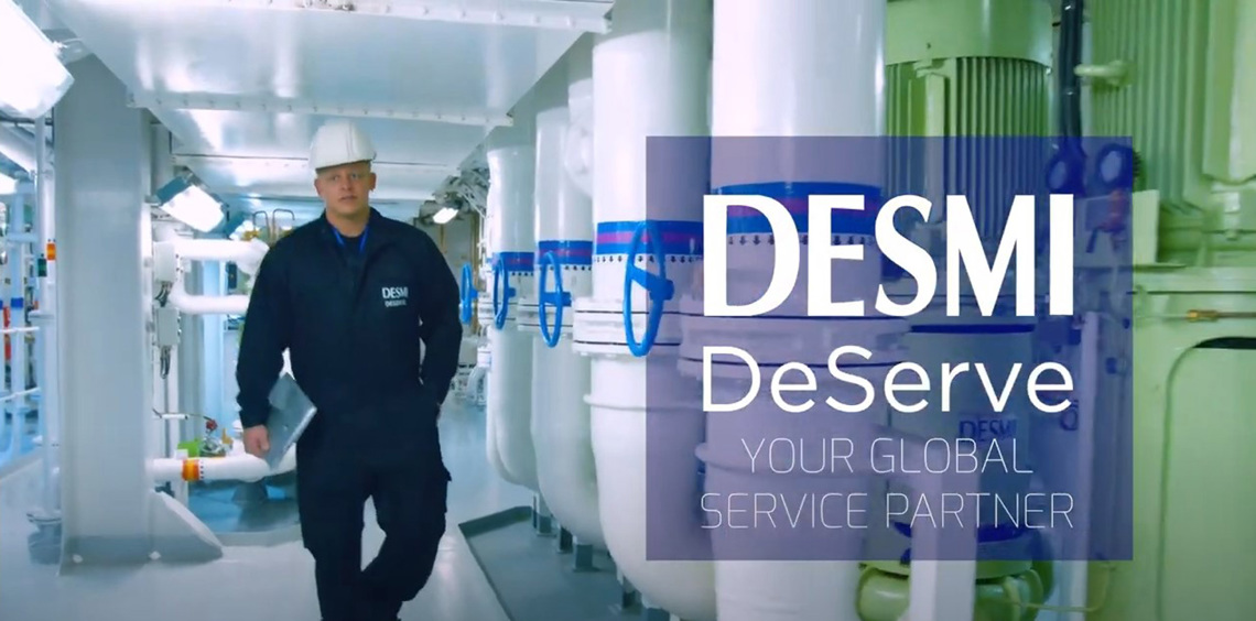 Trabajador con uniforme de DESMI caminando por una instalación industrial para el manejo de fluidos.