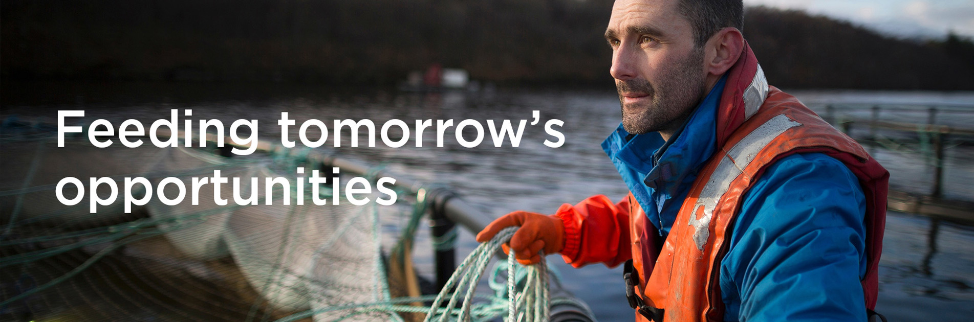 身穿安全装备的男子在水边,旁边有文字“Feeding tomorrow’s opportunities”。
