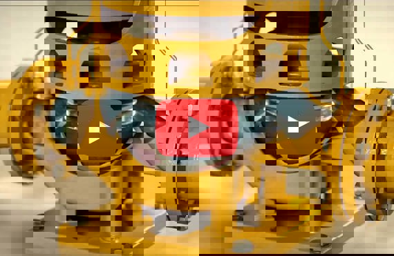 Bomba industrial amarilla con impulsor visible, con un icono de botón de reproducción superpuesto.