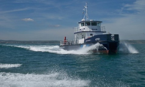 Blue vessel "Recovery 1" navigating through ocean waves under a clear sky.