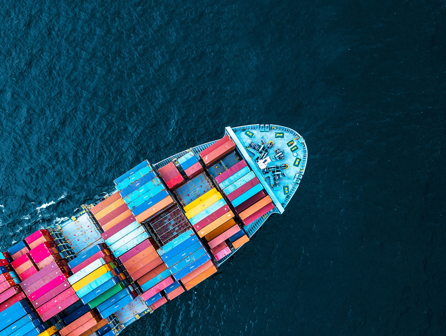 Aerial view of a cargo ship with colorful containers at sea.