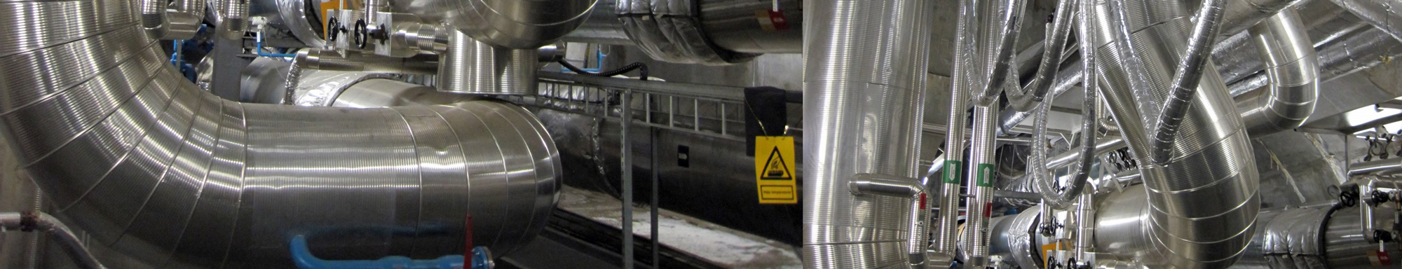 Complex network of stainless steel industrial pipes and valves in a facility.