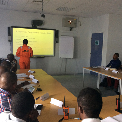 Classroom session with a presentation on predicting fate, led by instructor in orange.