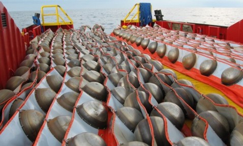 Rows of seismic air guns on a vessel deck for underwater exploration.