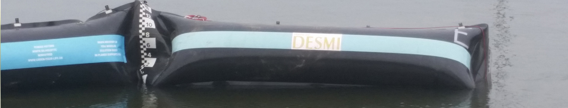 DESMI oil containment boom floating on the water surface for spill control.
